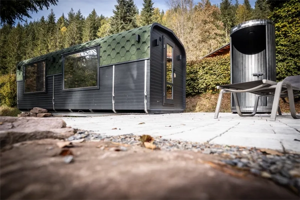 Augenbereich der Sauna mit Sonnenliegen und Außen dusche mit Blick auf die Sauna und die Natur
