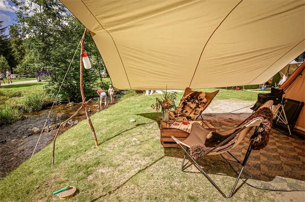Zelt mit Sonnen liegen auf grüner Wiese, Idyllisch gelegen direkt am Funkelndem Bach im Camping Langenwald