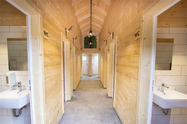 Moderner,heller Waschraum im Camping Langenwald mit Holzwänden, Einzelkabinen und Waschbecken
